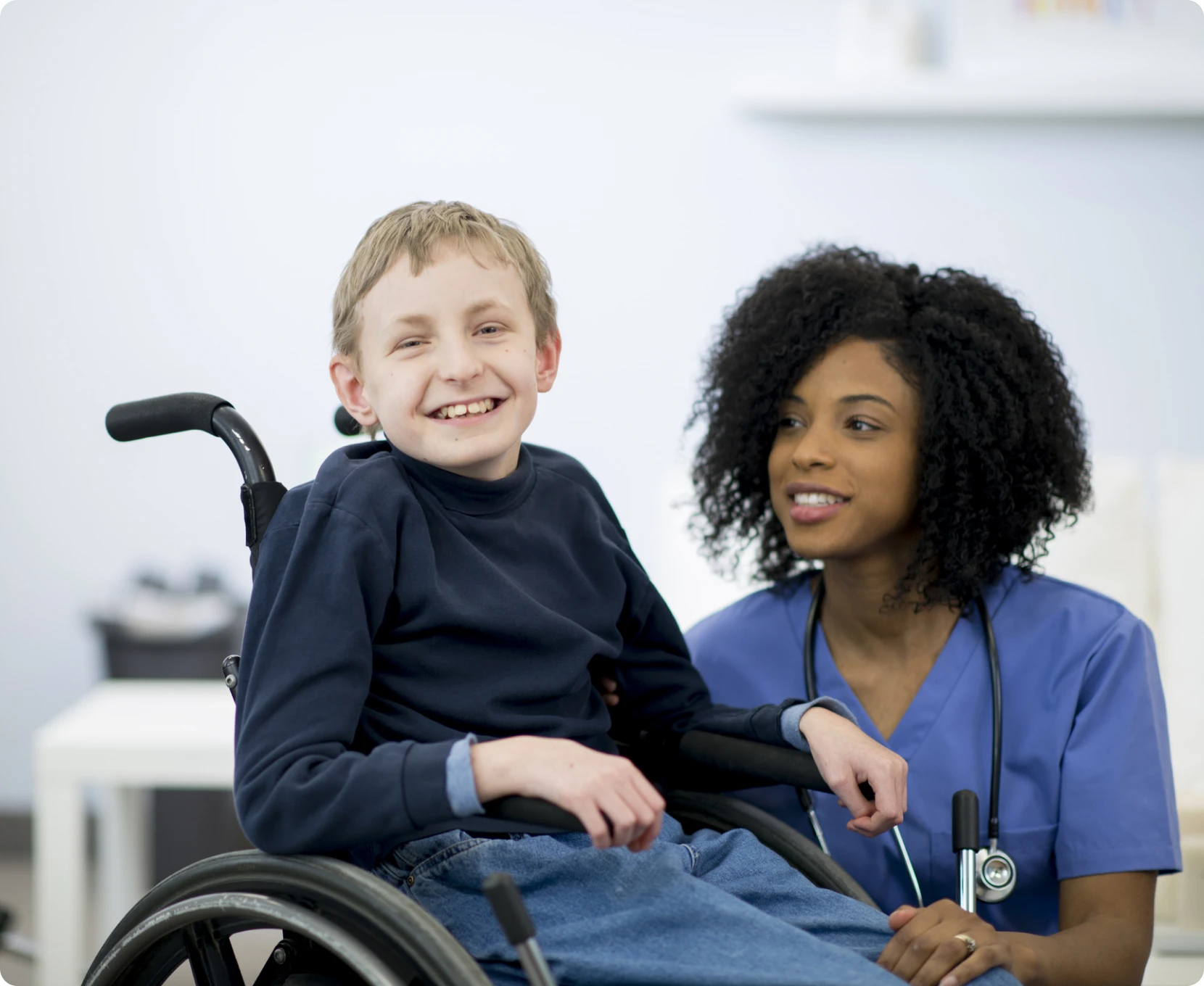 Boy and nurse sitting together, smiling